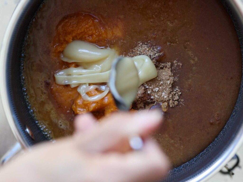 adding sweetened condensed oat milk into pot